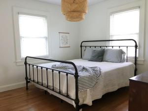 1 dormitorio con 1 cama negra y 2 ventanas en 1940's Bungalow near Downtown & UT Campus, en Knoxville