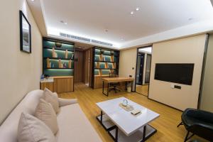 ein Wohnzimmer mit einem Sofa und einem TV in der Unterkunft Atour Hotel (Dongying Huanghe Road) in Dongying
