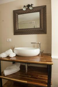 ein Waschbecken auf einem Holztisch mit einem Spiegel in der Unterkunft Sobe Bile in Pag
