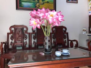 eine Vase voller rosa Blumen auf dem Tisch in der Unterkunft 105 Láng Hạ in Hanoi