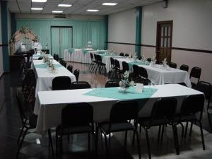 uma sala com mesas e cadeiras com toalhas de mesa brancas em Hotel Alcala em David