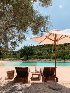 two chairs and an umbrella next to a pool at IUTA Glamping & Farm in Noto
