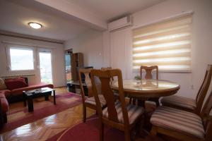 a living room with a table and chairs and a couch at CasaBlanca in Trebinje