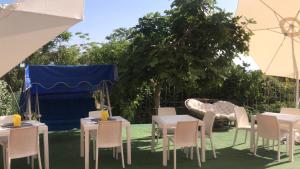 un groupe de tables et de chaises sous une tente bleue dans l'établissement Villa Saturno, à Tropea