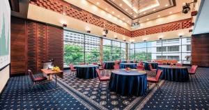 Großes Zimmer mit Tischen, Stühlen und Fenstern in der Unterkunft Royal Plaza on Scotts in Singapur