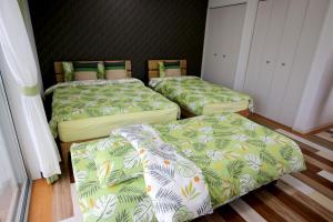three beds in a small room with at guesthouse yu -SEVEN Hotels and Resorts- in Yomitan