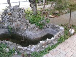 a stone fountain with a pond in a garden at B&B William in Padova