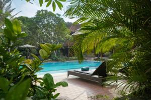 uma piscina com uma chaise longue ao lado de um resort em Bumas Hotel em Sanur