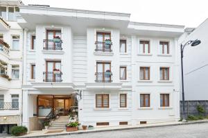 ein weißes Gebäude mit Fenstern und Balkonen in der Unterkunft Albinas Hotel Old City in Istanbul