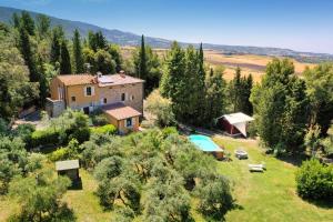 uma vista aérea de uma quinta com uma casa e uma piscina em La Locanda del Barbagianni em Santa Luce