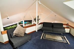 un soggiorno con 2 sedie e un divano di Beach Views Holiday Home a Nelson
