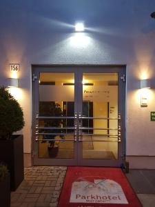 une porte d'entrée d'un bâtiment avec des lumières allumées dans l'établissement Parkhotel Marzahn, à Berlin