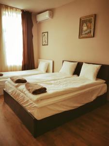 2 camas individuales en un dormitorio con ventana en Къща за гости ДаРая, en Veliko Tŭrnovo