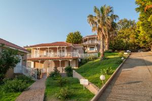a large house with palm trees and a driveway at Iliovasilema in Platy