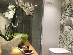 a bathroom with a toilet and a green sink at Egusa73 Favignana in Favignana +27 photos