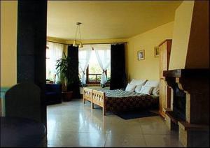 a living room with a bed and a large window at Palatinus Apartmanok in Keszthely