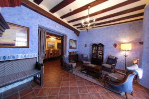 Las Cuevas de Cañart的住宿－Aparthotel SPA Don Iñigo de Aragón，客厅设有蓝色的墙壁、椅子和沙发