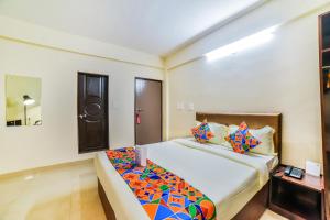 um quarto com uma cama grande e almofadas coloridas em FabHotel K7 Trends With Pool, Baga Beach em Calangute