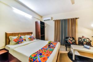 a bedroom with a bed and a desk and a chair at FabHotel K7 Trends With Pool, Baga Beach in Calangute