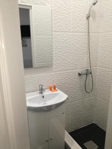 a white bathroom with a sink and a shower at Yraida's house Constanta in Constanţa