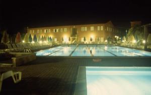 a large swimming pool at night with a building at Santa Caterina in San Vincenzo