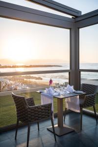 a dining room with a table with a view of the ocean at Porto Platanias Beach Luxury Selection - Adults Only in Plataniás