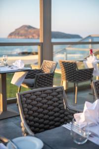 a restaurant with tables and chairs and a view of the ocean at Porto Platanias Beach Luxury Selection - Adults Only in Plataniás