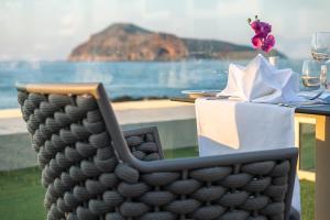 a table with a table with a table cloth and a table with wine glasses at Porto Platanias Beach Luxury Selection - Adults Only in Plataniás