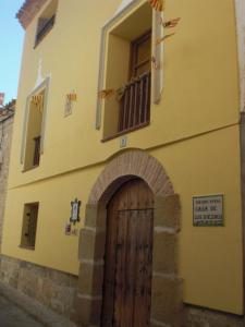 un edificio amarillo con puerta de madera y ventana en Casa De Los Diezmos en Alborge