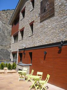 a group of tables and chairs outside of a building at Obaga Blanca & Spa in Canillo