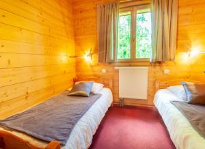 モルジヌにあるClair Matin 2のベッド2台 木製の壁の部屋