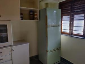 a kitchen with a refrigerator and a window at Raahgir in Nashik