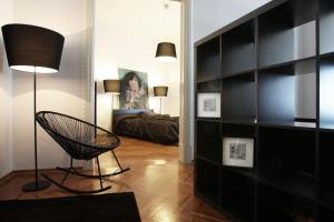 Pokój z krzesłem i dużą półką na książki w obiekcie Valsabbion City Suite w Puli