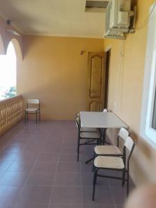 een kamer met een tafel en stoelen en een raam bij House Anna in Gonio