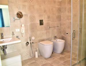 a bathroom with a toilet, sink, and bathtub at TOREMARE SUITE MARZAMEMI in Marzamemi