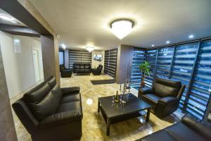 a living room with leather chairs and a table at Стаи за гости Десита in Blagoevgrad