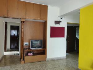 a room with a tv on a shelf and a room with cabinets at Raahgir in Nashik
