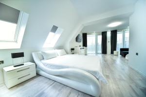 a white bedroom with a large white bed and a desk at Стаи за гости Десита in Blagoevgrad
