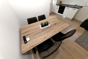 a wooden table with chairs and a remote control on it at Apartment Tia in Zadar