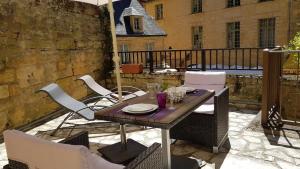 サルラ・ラ・カネダにあるL'Appartement du "Coup de Coeur de Sarlat"の木製テーブルと椅子付きのバルコニー