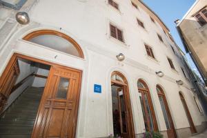 a building with a wooden door and a staircase at Rooms Nekic 1 in Zadar