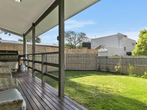 a backyard with a deck with a fence at COASTAL BOHO VIBES FREE WIFI & NETFLIX - SURFSIDE in Inverloch