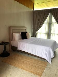 a bedroom with a large bed with white sheets and pillows at Laman Villa Port Dickson in Port Dickson
