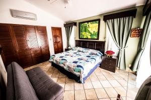 een slaapkamer met een bed en een bank bij Villa Holiday Playa Del Carmen in Playa del Carmen