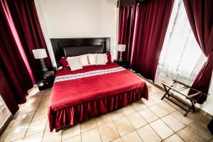 een slaapkamer met een groot rood bed en rode gordijnen bij Villa Holiday Playa Del Carmen in Playa del Carmen