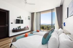 two beds in a room with a large window at Luxury Verano Residence 3 Bedroom Seaview Villa Chaweng Noi in Bophut  +67 photos