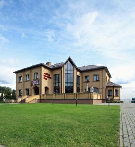 a large building with a grass field in front of it at Hotel Felicia in Riga