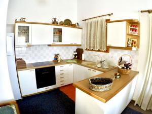 a kitchen with white cabinets and a counter top at Villa Vasiliki in Palioúras