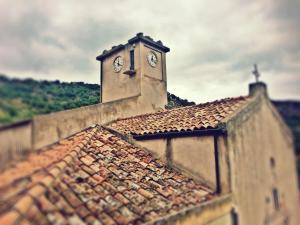 a building with a clock tower on top of it at The Clock Houses Borgo Gallodoro in Letojanni