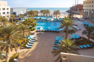 uma vista aérea de um resort com piscina e praia em The Palms Beach Hotel & Spa em Kuwait